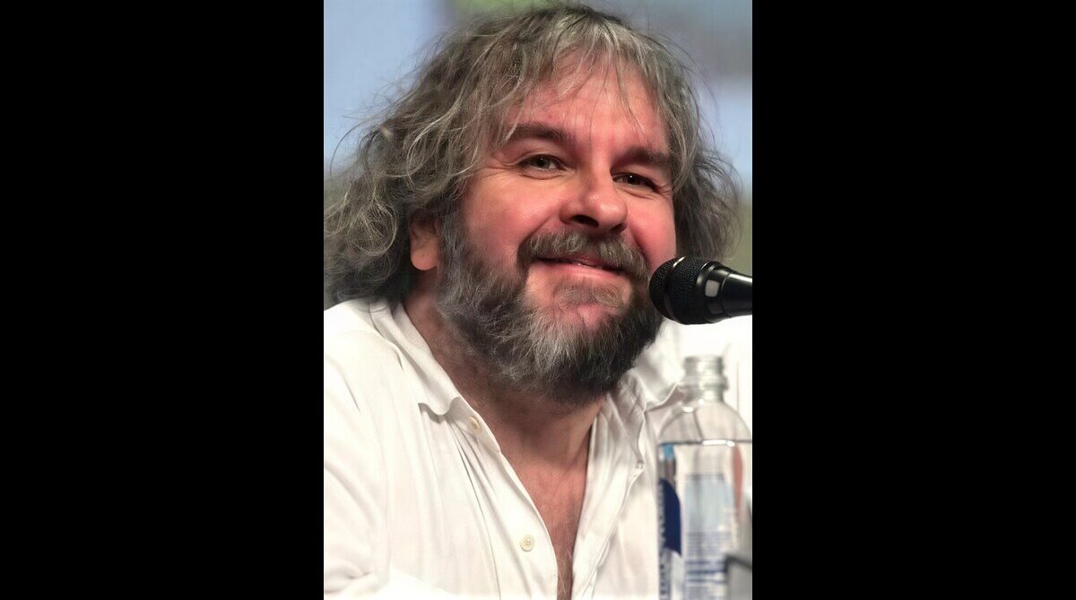 Peter Jackson smiling at a movie premiere in a black suit during a Hollywood event in 2026