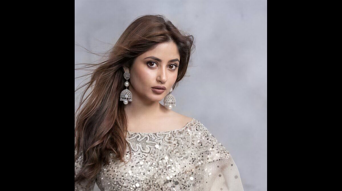 Pakistani actress Sajal Aly smiling at a red carpet event with glamorous fashion style