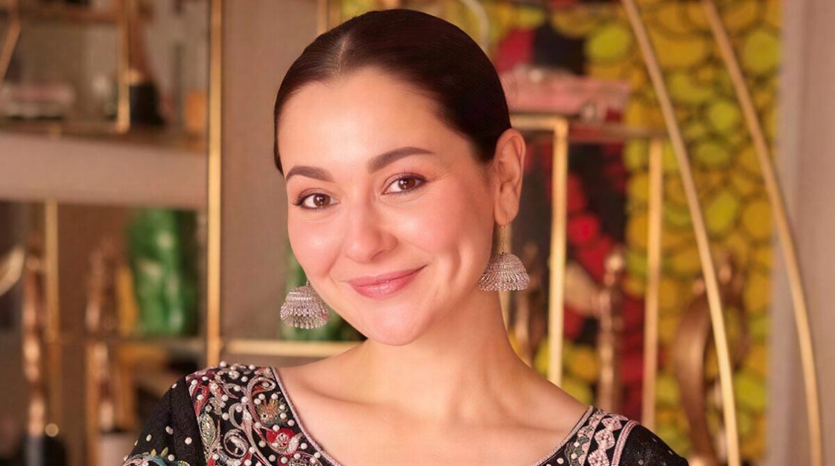 Hania Aamir smiling during a glamorous photoshoot in 2026