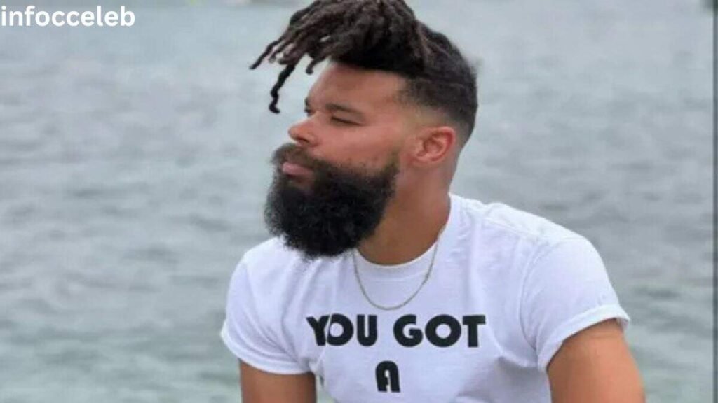 Damon Darling sitting by the water with his signature beard and hairstyle, highlighting Damon Darling Net Worth and career success in 2026.
