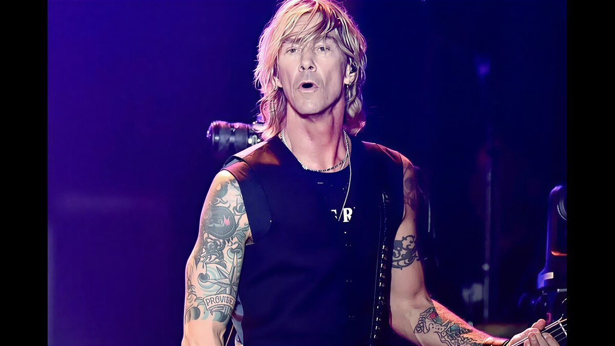 Duff McKagan performing on stage with bass guitar